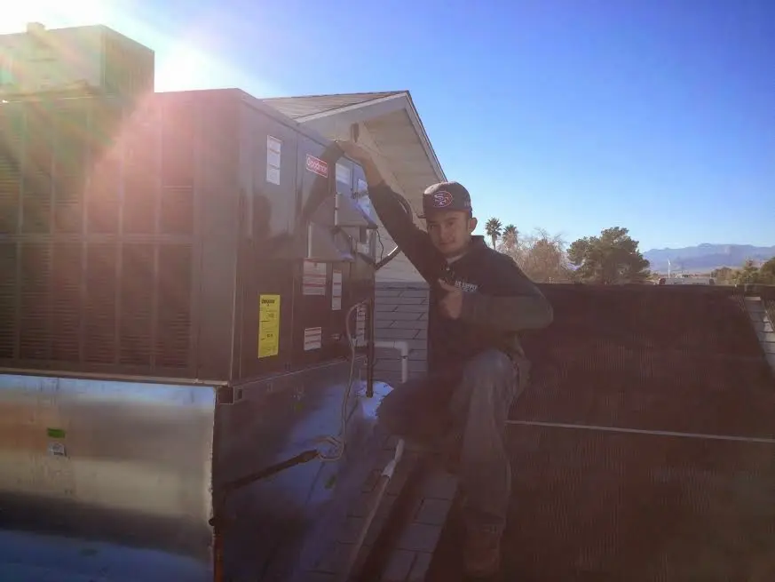 HVAC technician performing AC Tune-Up on a rooftop unit in Marion